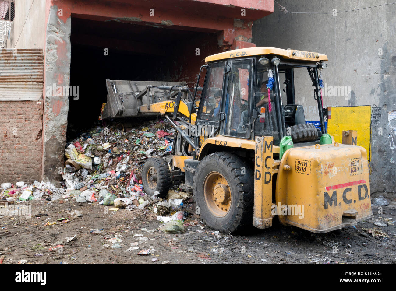 Caricatore a estremità anteriore spostando gran mucchio di rifiuti urbani nella Vecchia Delhi, India Foto Stock