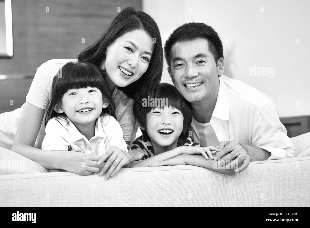 Ritratto di una famiglia asiatica con due bambini, felice e sorridente, in bianco e nero. Foto Stock