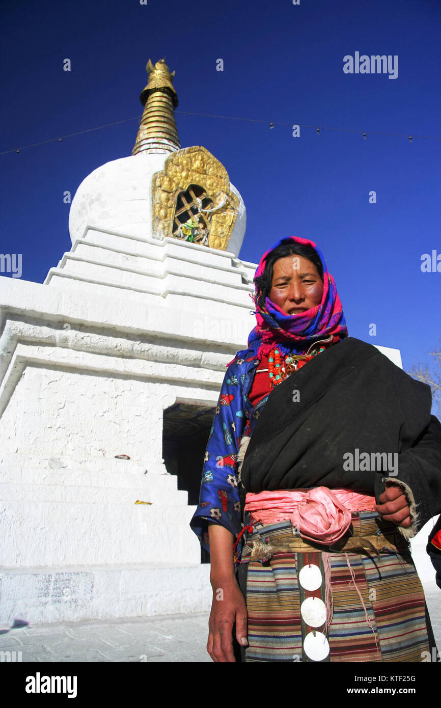 Il Tibetano donna in piedi accanto a un chorten a Lhasa, in Tibet Foto Stock