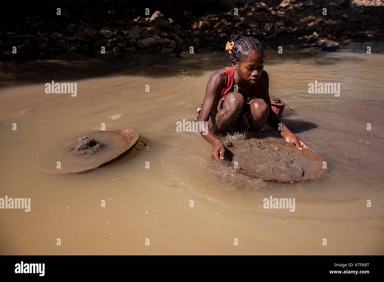 Un schoolgirl padelle per oro nelle montagne vicino Ankavandra, Madagascar Foto Stock