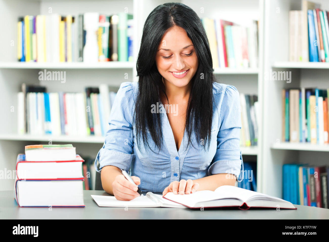 Felice apprendimento dello studente nella libreria Foto Stock