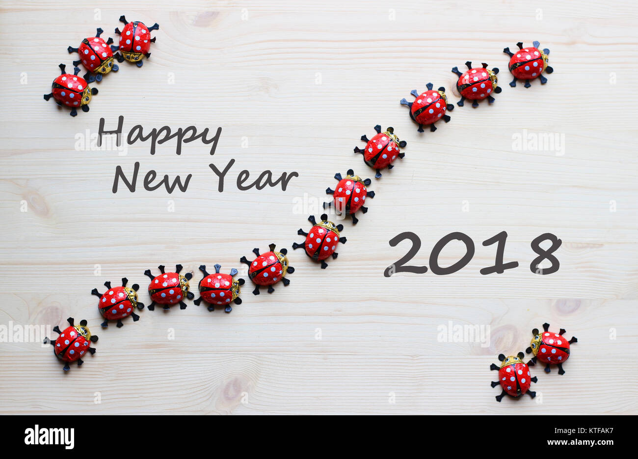 Nuovo anno 2018 biglietto di auguri con chocolate ladybugs su legno luminoso Foto Stock