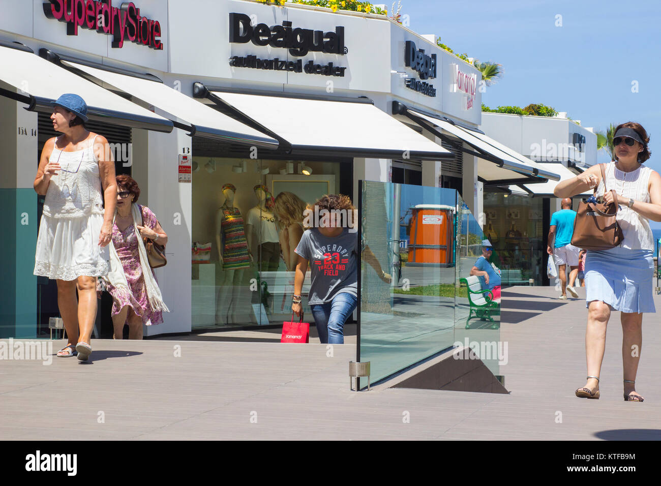 Shoppers fretta lungo una strada shopping a Playa de las Americas in Teneriffe Foto Stock