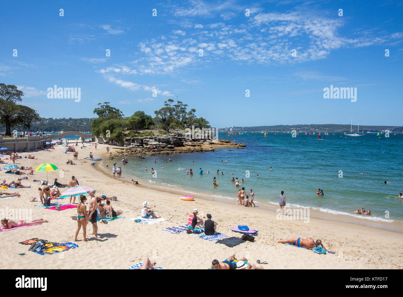 Persone che si rilassano e prendono il sole sulla spiaggia di Balmoral a Mosman, Sydney, NSW, Australia, con isola rocciosa Foto Stock