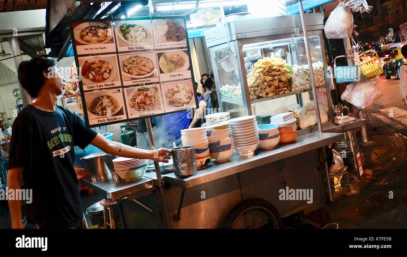 Uomo asiatico cibo di strada notte tempo di vendita di noodle caldo bordo menu Bangkok Thailandia fare s vivere Foto Stock