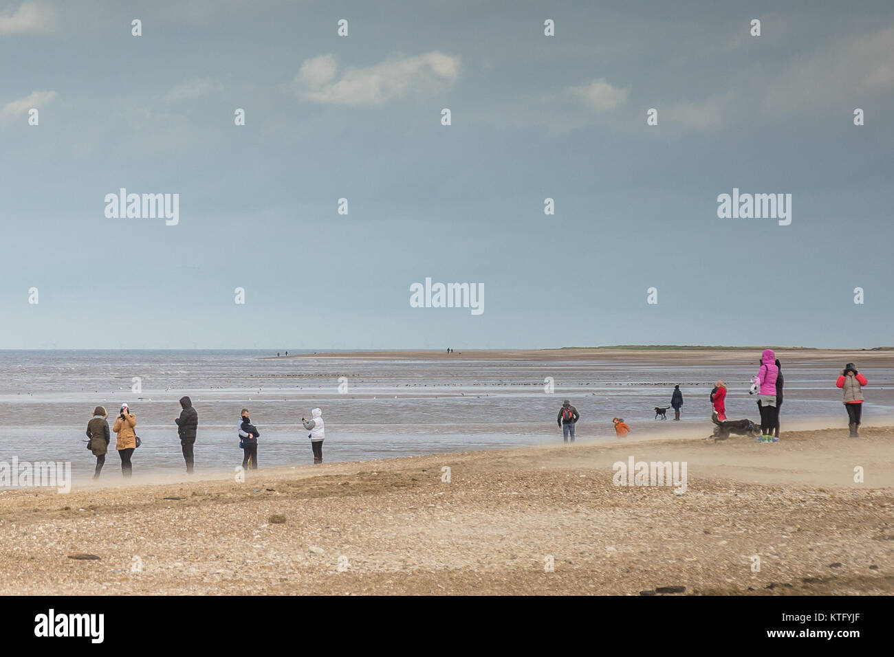 Per coloro che godono di una luminosa giornata invernale a piedi sulla spiaggia Foto Stock