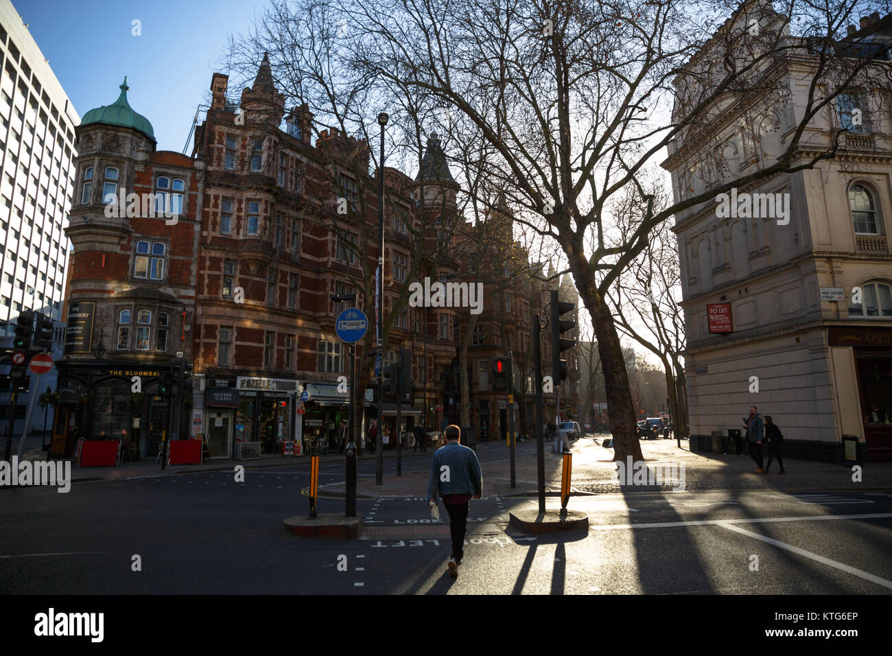 La gente camminare fuori sul marciapiede durante il tramonto a Bloomsbury - Londra, Inghilterra, Regno Unito Foto Stock