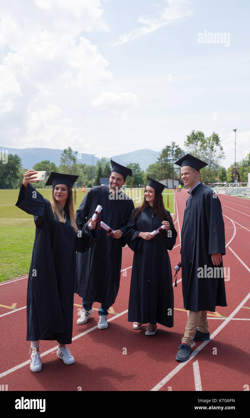 Istruzione, graduazione e concetto di persone - gruppo di felice gli studenti internazionali in mortaio e schede di corso di laurea gli abiti con diplomi Foto Stock