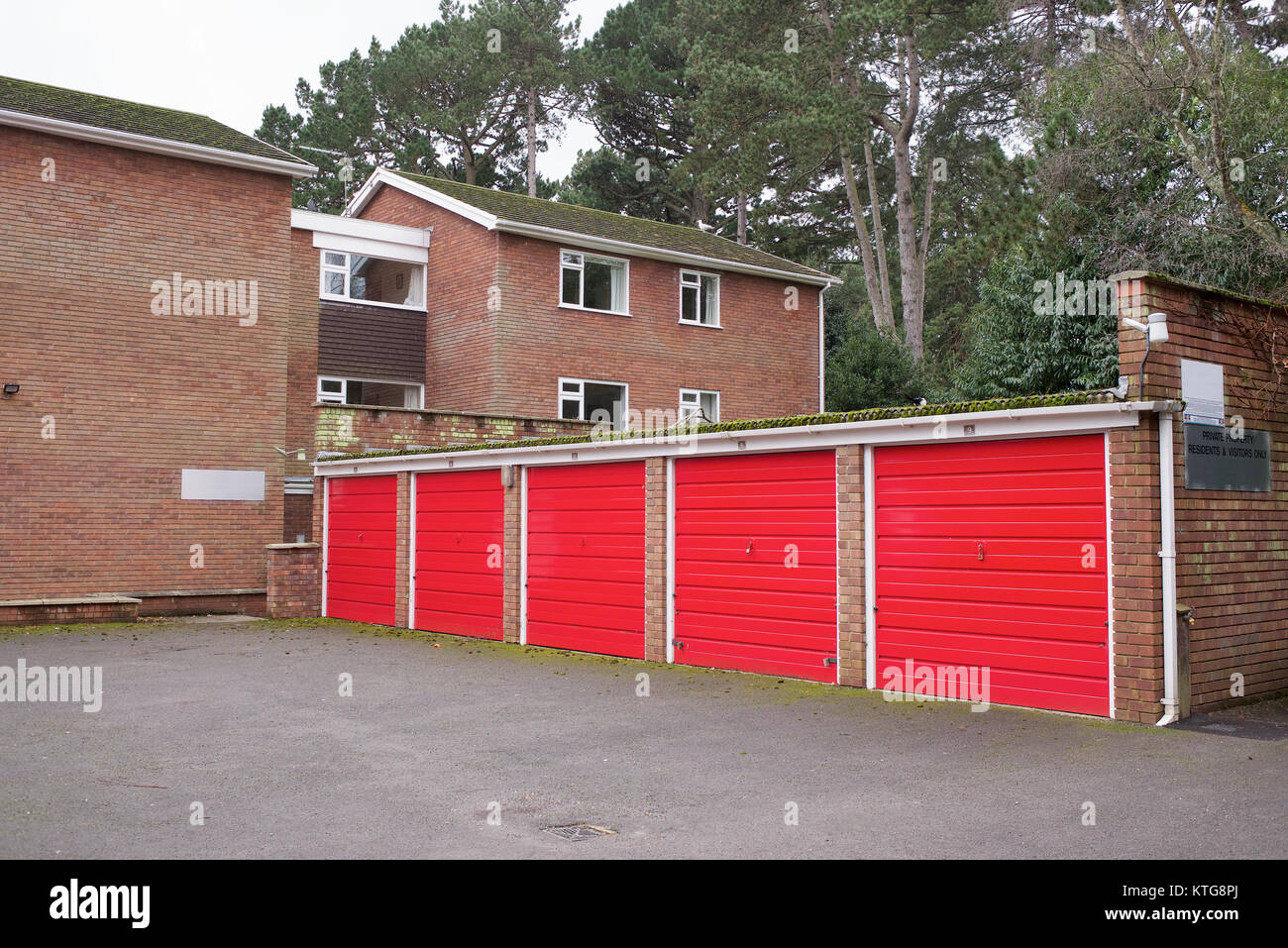 Garage con porte rosse e complesso di appartamenti Foto Stock