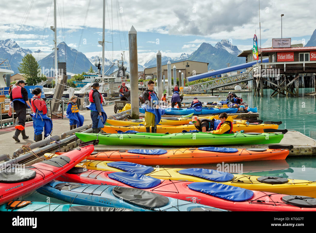 Kayakers indossando ingranaggio di sicurezza, ricevendo istruzioni prima di uscire piccola barca porto. Foto Stock