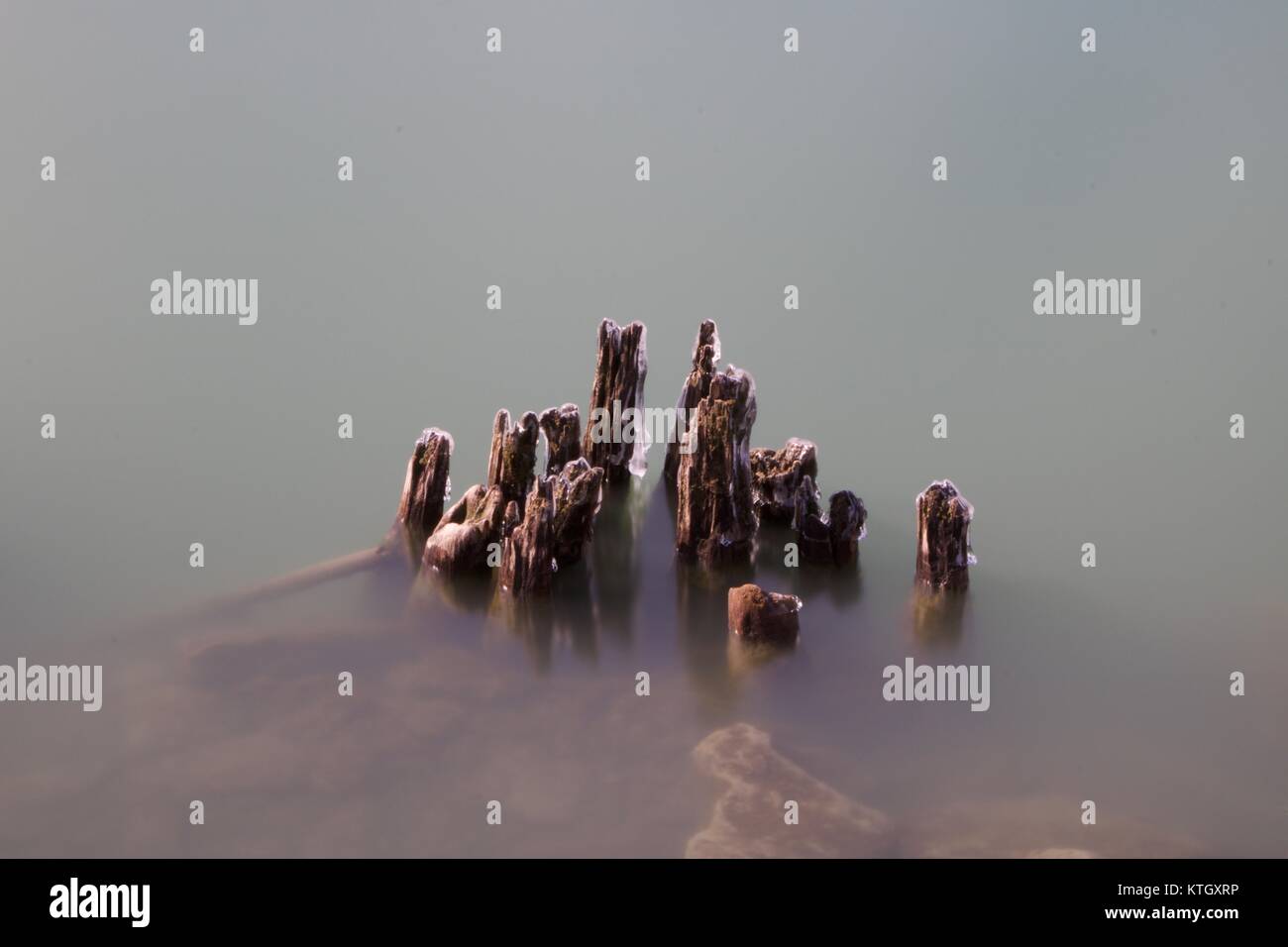 Ore diurne lunga esposizione fotografica di stock di resti di icy tralicci in legno sporgente dal Lago Erie in Buffalo, New York in Erie County Foto Stock