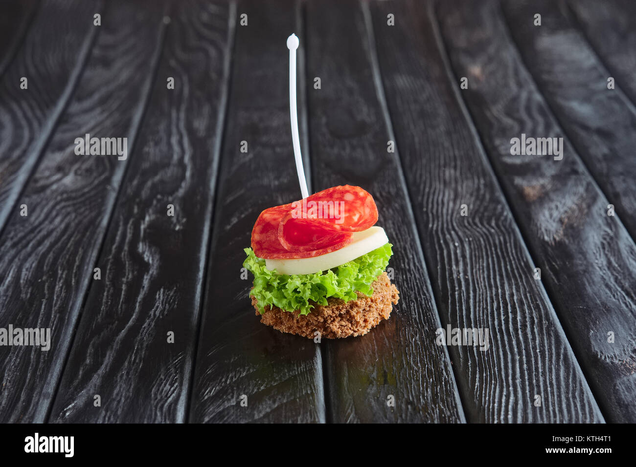 Antipasto per la ricezione. Piccoli sandwich con salsiccia, sheese e foglia di insalata su spiedino Foto Stock