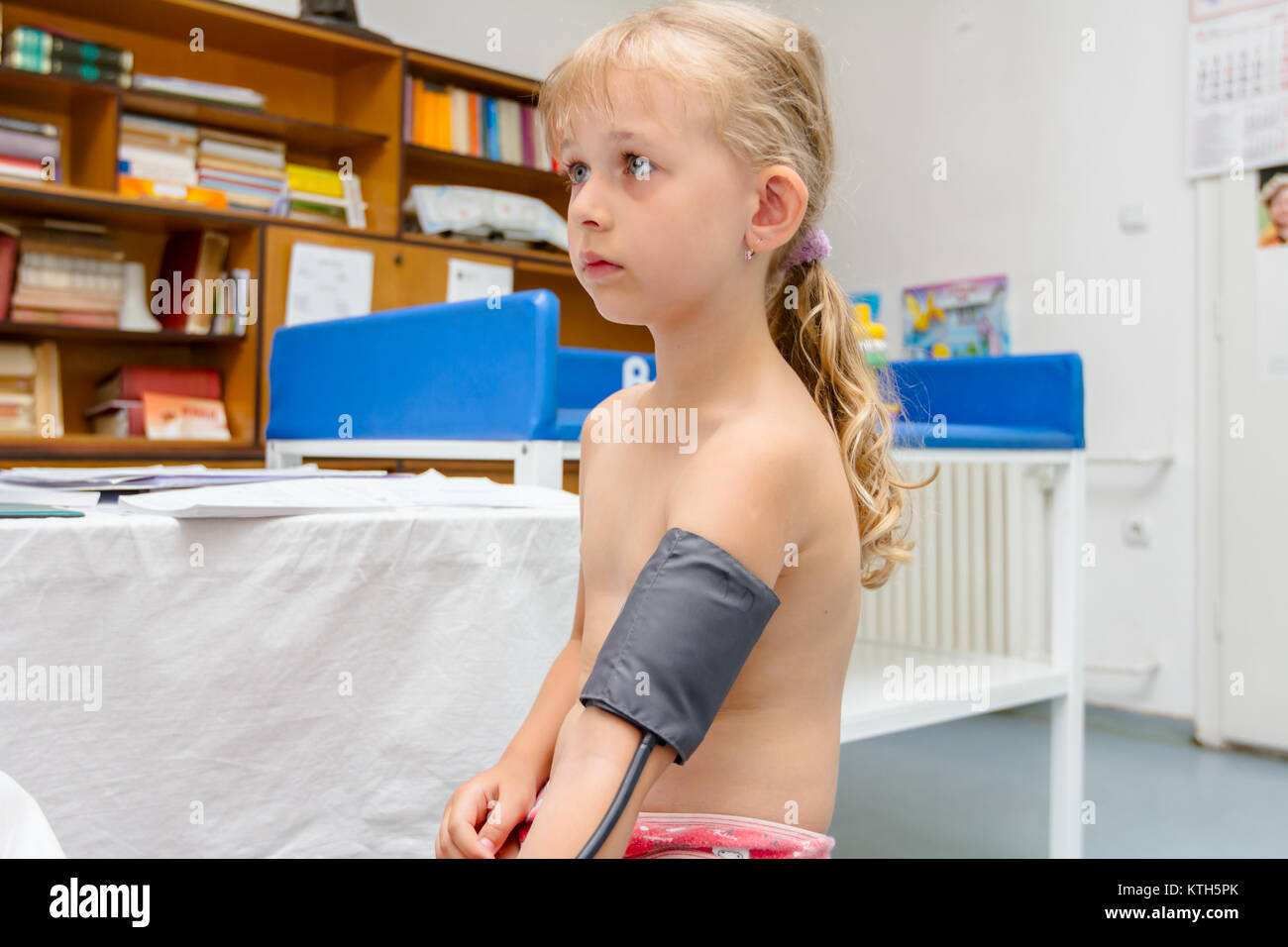 Bambina è avente esame sistematico con le apparecchiature per misurare la pressione del sangue nell'ufficio del medico. Foto Stock