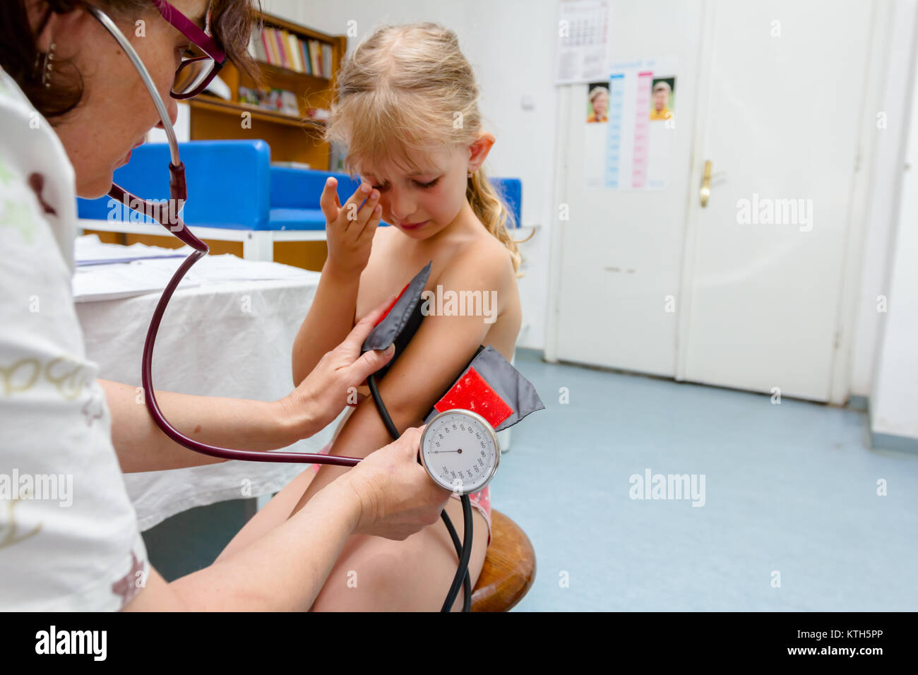 Bambina è avente esame sistematico con le apparecchiature per misurare la pressione del sangue nell'ufficio del medico. Foto Stock