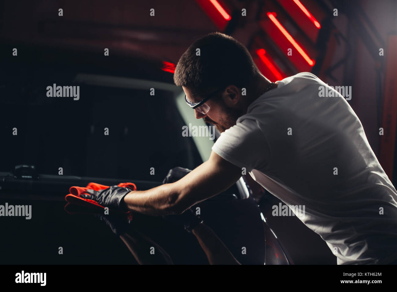 Dettagli auto - l'uomo detiene la microfibra in mano e leviga la vettura Foto Stock