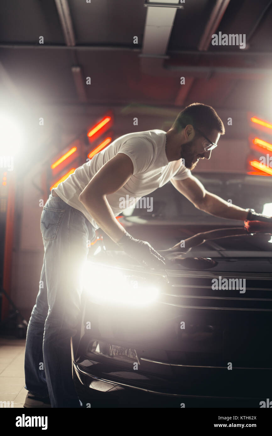 Uomo Macchina di pulizia con un panno in microfibra, auto che dettaglia o concetto valeting Foto Stock