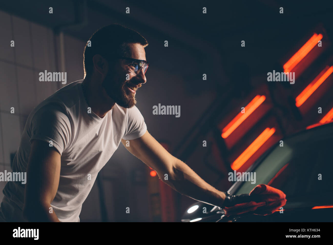 Dettagli auto - l'uomo detiene la microfibra in mano e leviga la vettura Foto Stock