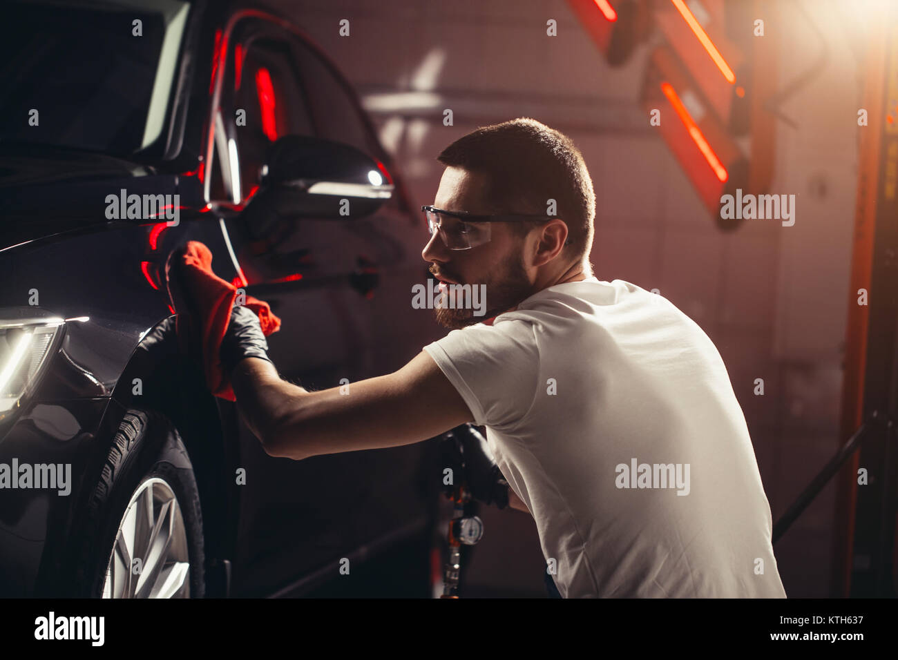 Uomo Macchina di pulizia con un panno in microfibra, auto che dettaglia o concetto valeting Foto Stock