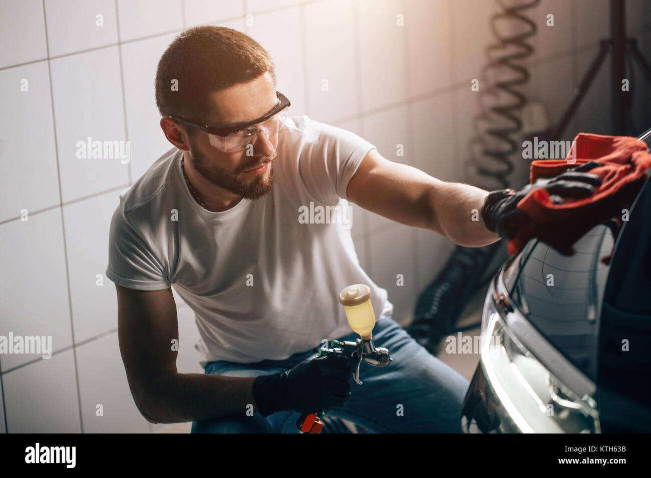 Uomo Macchina di pulizia con un panno in microfibra, auto che dettaglia o concetto valeting Foto Stock