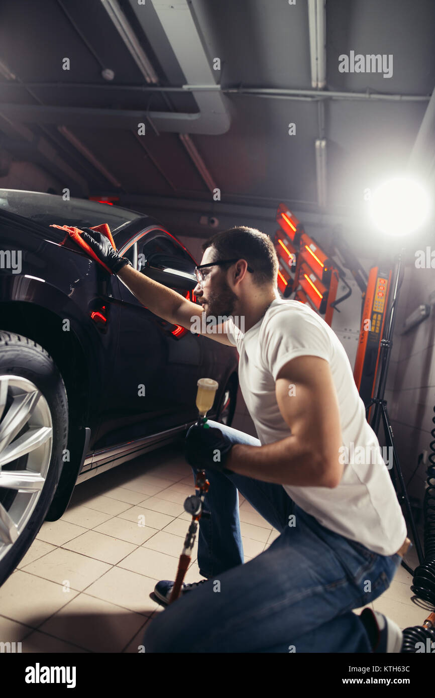 Uomo Macchina di pulizia con un panno in microfibra, auto che dettaglia o concetto valeting Foto Stock