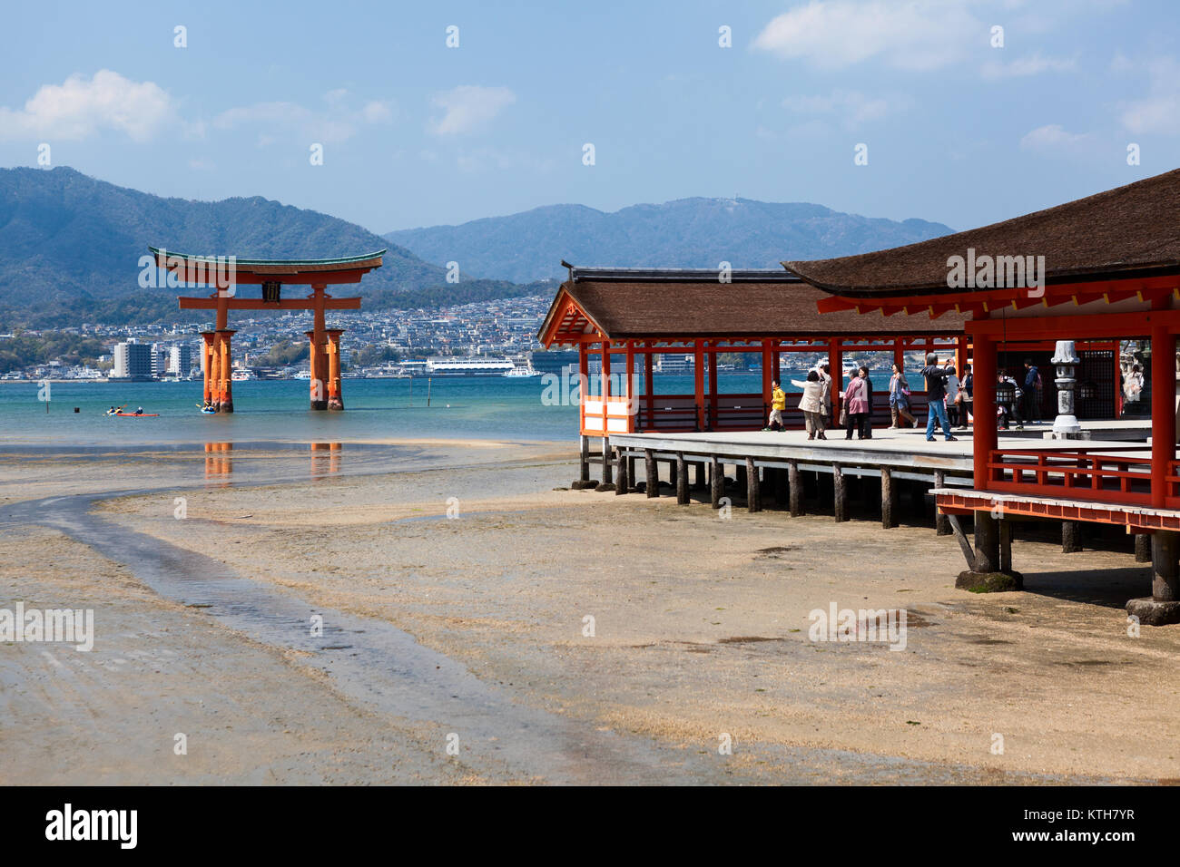 ITSUKUSHIMA, Giappone-CIRCA APR, 2013: Orange edifici in legno del santuario di Itsukushima sono sulla costa dell'isola di Miyajima e galleggiante grande Torii è in ba Foto Stock