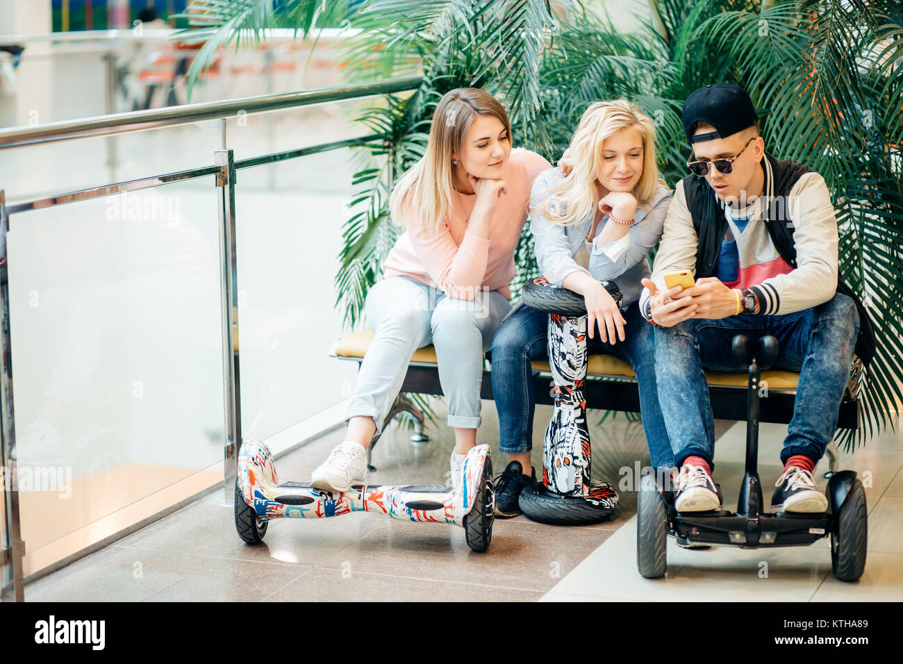 Gruppo di persone su scooter elettrico hoverboard seduto al banco di lavoro  e utilizzando il telefono Foto stock - Alamy
