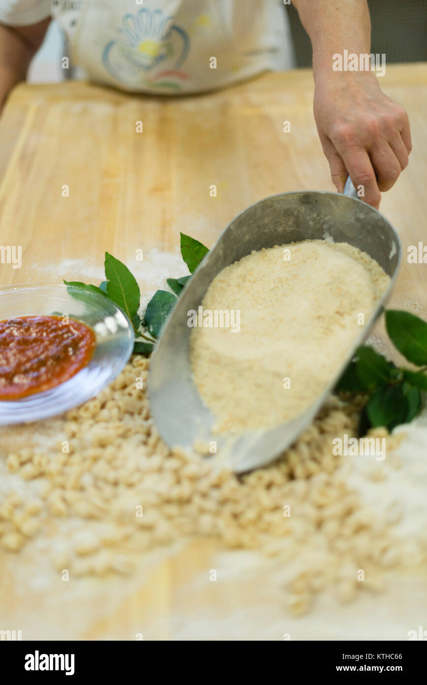 Donna fare e preparare pisarei gnocchi di pasta tipico da Emilia Romagna, Piacenza, Italia presso il ristorante cucina preparazione Foto Stock