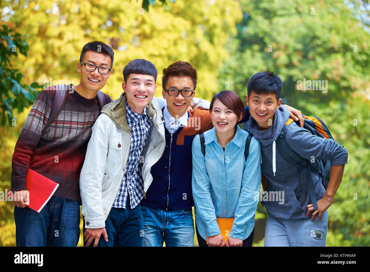 Cinque felice Collegio cinese agli studenti di sorridere alla telecamera nel Campus Foto Stock