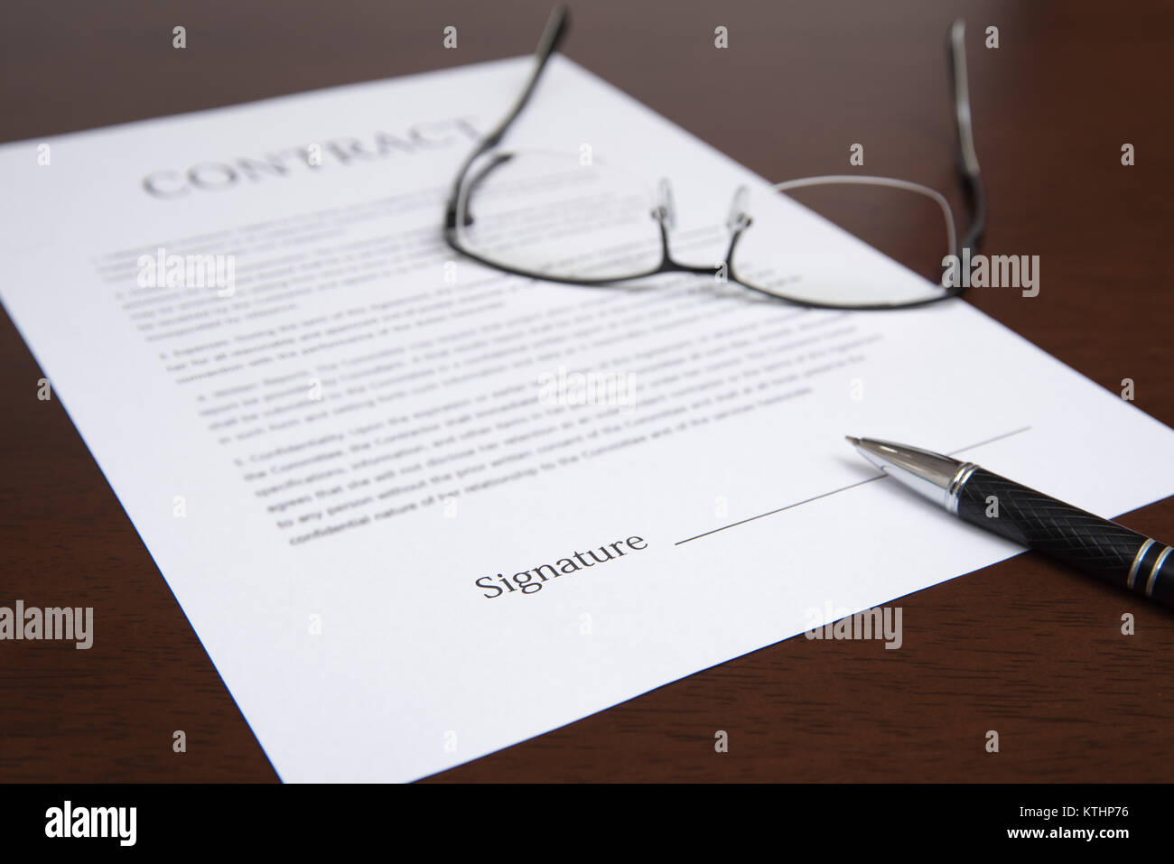 Il concetto con un contratto, bicchieri e penna sulla scrivania. Foto Stock