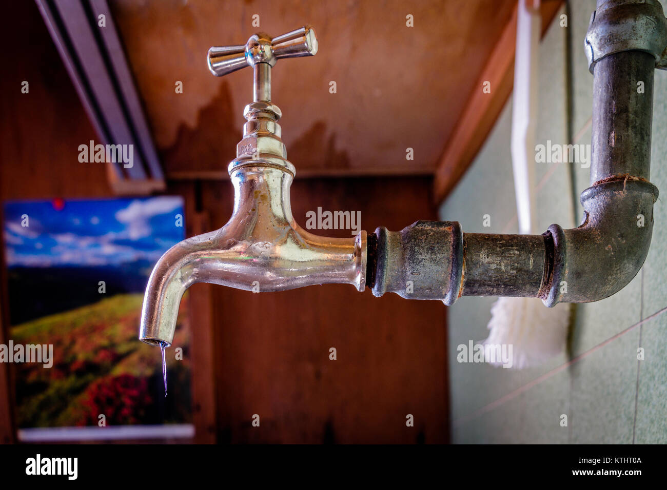 Una cucina congelati acqua gru in una Svizzera incolte baita di montagna. Non vi è stato alcun riscaldamento per un tempo e che è il motivo per cui il ghiacciolo è venuta fuori di t Foto Stock