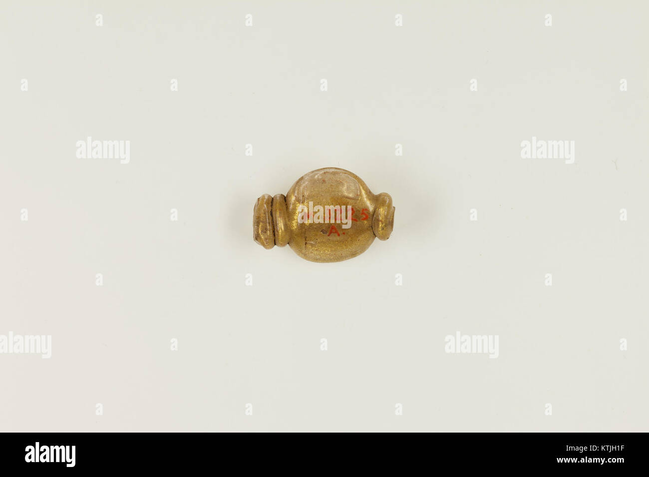 Questa perla, parte della collezione MET, presenta elementi di design complessi. L'artefatto è notevole per la sua artigianalità e il contesto storico, che riflette antiche pratiche decorative. Foto Stock
