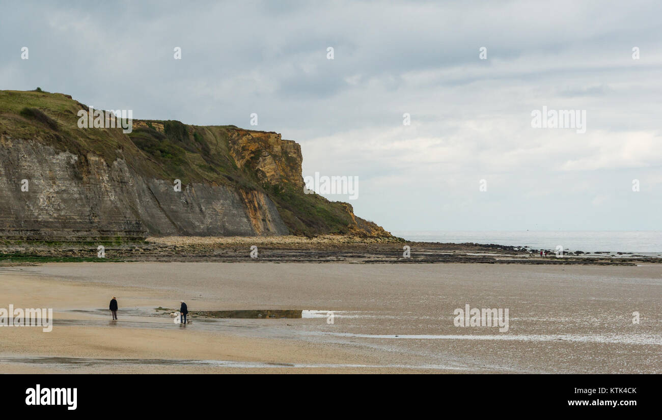 La spiaggia di Arromanches a Calvados, in Francia, con la bassa marea, offre una vista sulla sua costa unica e sul suo significato storico, specialmente in relazione agli eventi della seconda guerra mondiale. Foto Stock