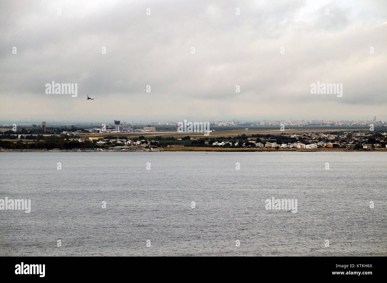L'aeroporto di Bari, situato in Italia, è visto dal mare in questa prospettiva. L'immagine evidenzia la vicinanza dell'aeroporto alla costa e l'integrazione delle infrastrutture di trasporto aereo e marittimo nella regione. Foto Stock