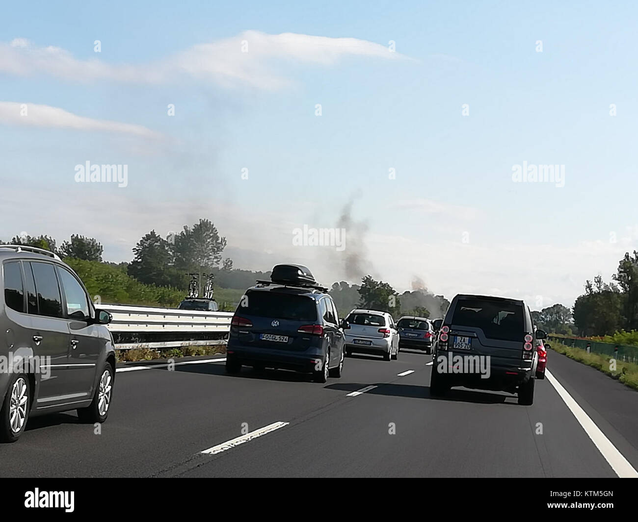 Questa immagine raffigura un incendio di un'auto nel 2017, che mostra un veicolo inondato di fiamme, con squadre di pronto intervento probabilmente presenti sulla scena. Foto Stock