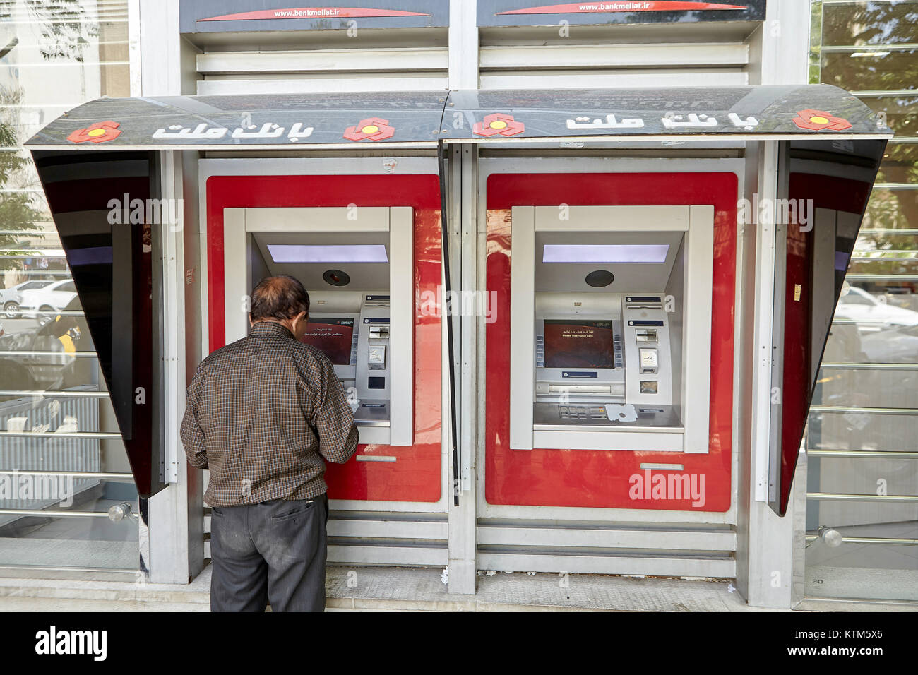 Yazd, Iran - 22 Aprile 2017: Anziani iraniano che preleva denaro da un bancomat. Foto Stock