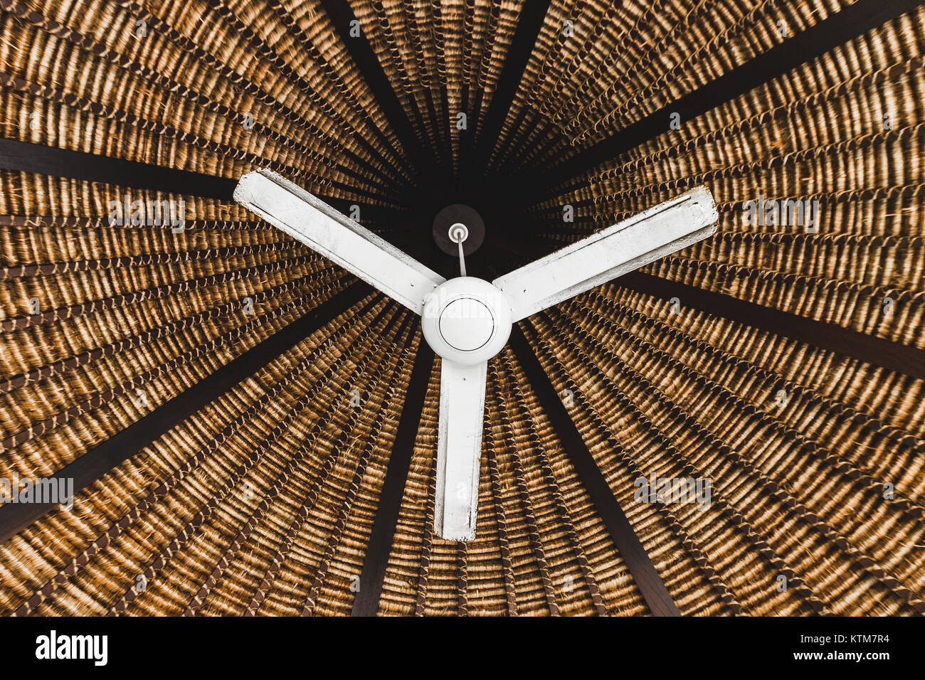 Il vecchio ventilatore da soffitto sospeso al di sotto di legno tetto di  vimini, stile asiatico Foto stock - Alamy