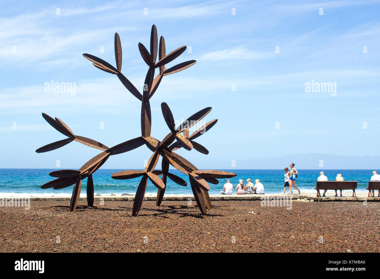 I turisti accanto alla grande in acciaio scultura di cactus sulla passeggiata delle isole Canarie località di Playa de las Americas in Teneriffe Foto Stock