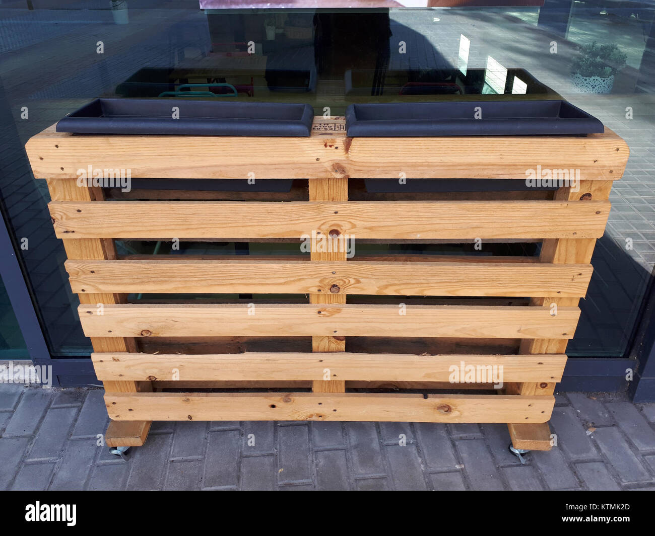 Fotografia di una piantatrice a pallet mobile di Barcellona, progettata nel 2017, con un pallet in legno riutilizzato come piantatrice con ruote, che mostra soluzioni innovative per il giardinaggio urbano. Foto Stock