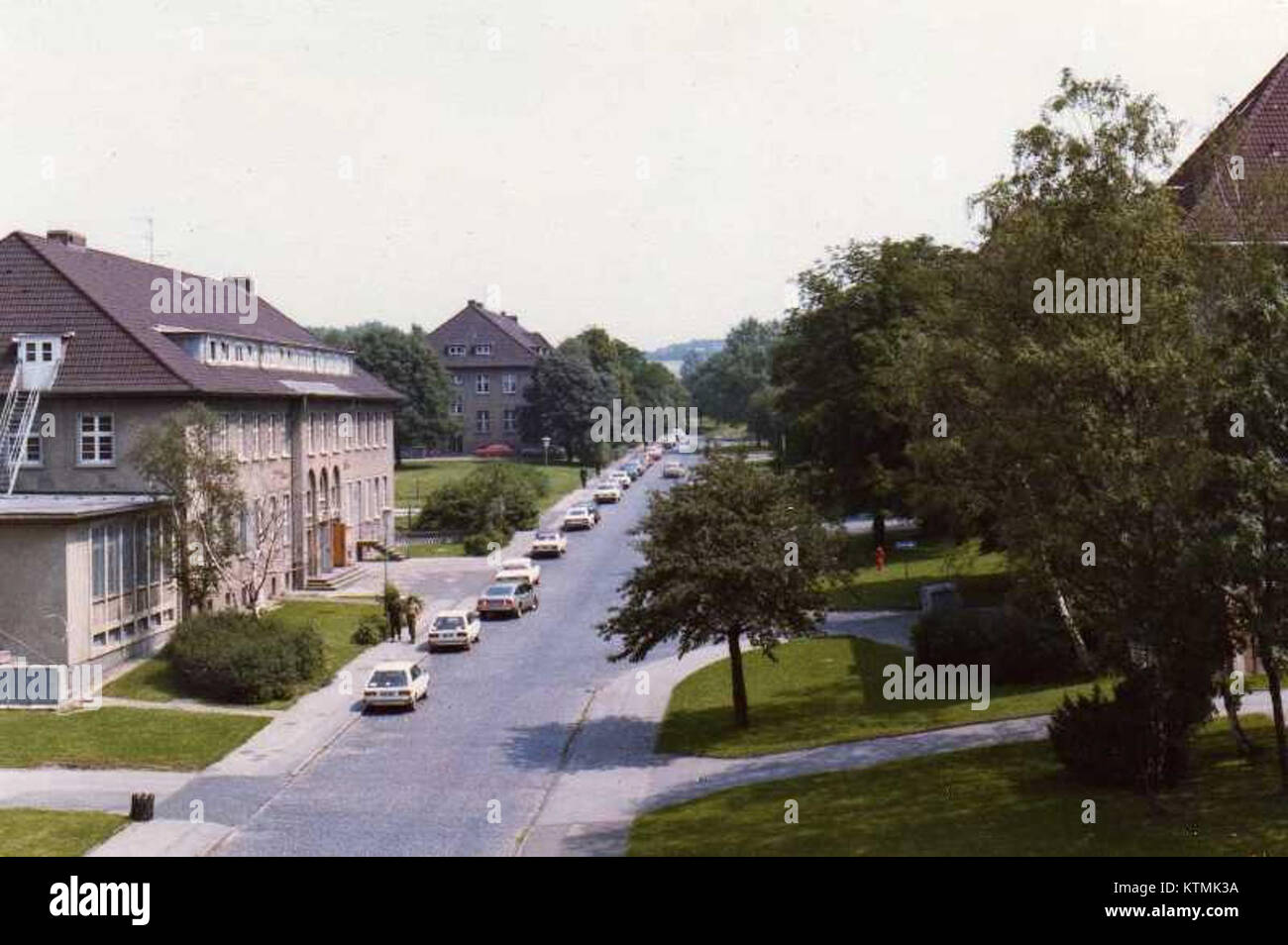 Una fotografia di Barker Barracks scattata negli anni '1980, che mostra la vista verso est. L'immagine cattura il layout architettonico e le caratteristiche militari della caserma, riflettendo il design e lo scopo operativo della struttura durante questo periodo della sua storia. Foto Stock