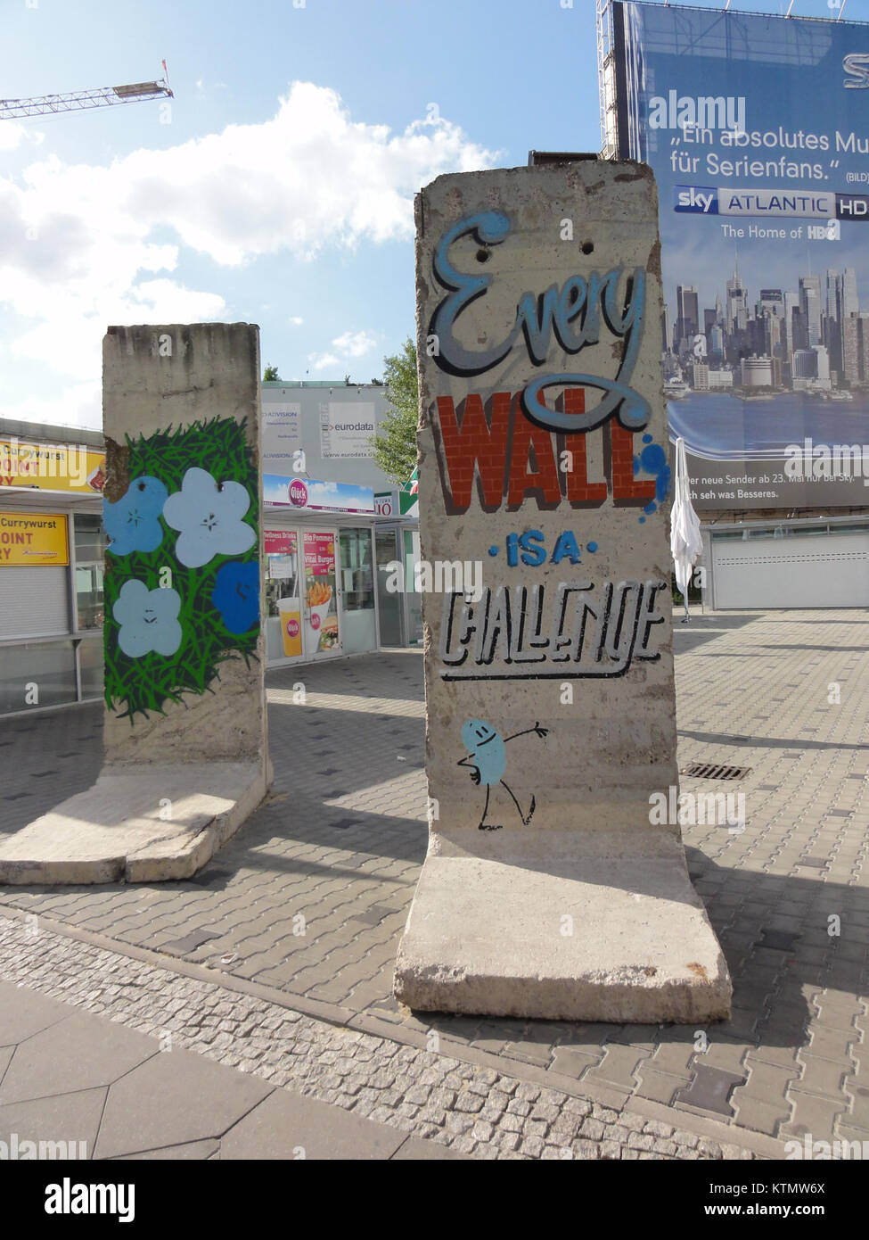 I graffiti sul muro di Berlino a Checkpoint Charlie divennero una forma di espressione durante la Guerra fredda, simboleggiando la resistenza e la divisione di Berlino Est e Ovest. Le colorate opere d'arte riflettono le tensioni politiche dell'epoca. Foto Stock