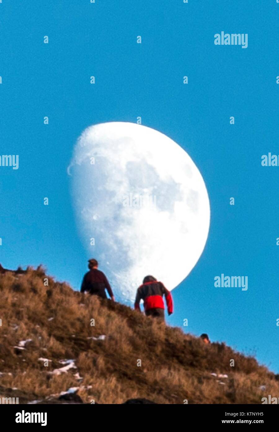 Edinburgh, Regno Unito. 28 dicembre, 2017. Walkers testa verso la luna che sorge durante gli ultimi minuti della giornata della luce sulle balze di Edimburgo Credito: ricca di Dyson/Alamy Live News Foto Stock