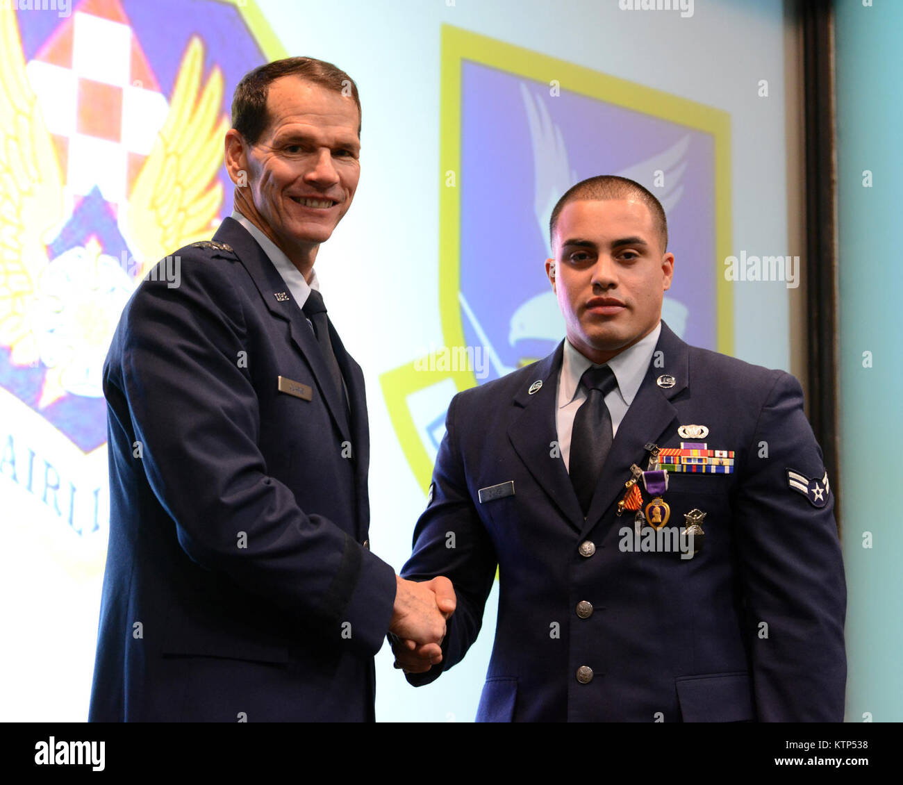 Direttore della Air National Guard, U.S. Air Force Lt. Gen. Stanley E. Clark III, elogia Airman Prima Classe Matteo Zuniga, 105Base Defense Squadron, che ha appena ricevuto un cuore viola medaglia durante una cerimonia di premiazione a Stewart Air National Guard Base, N.Y. Il 2 marzo 2014. (U.S. Air National Guard foto di Tech. Sgt. Michael OHalloran/rilasciato) Foto Stock