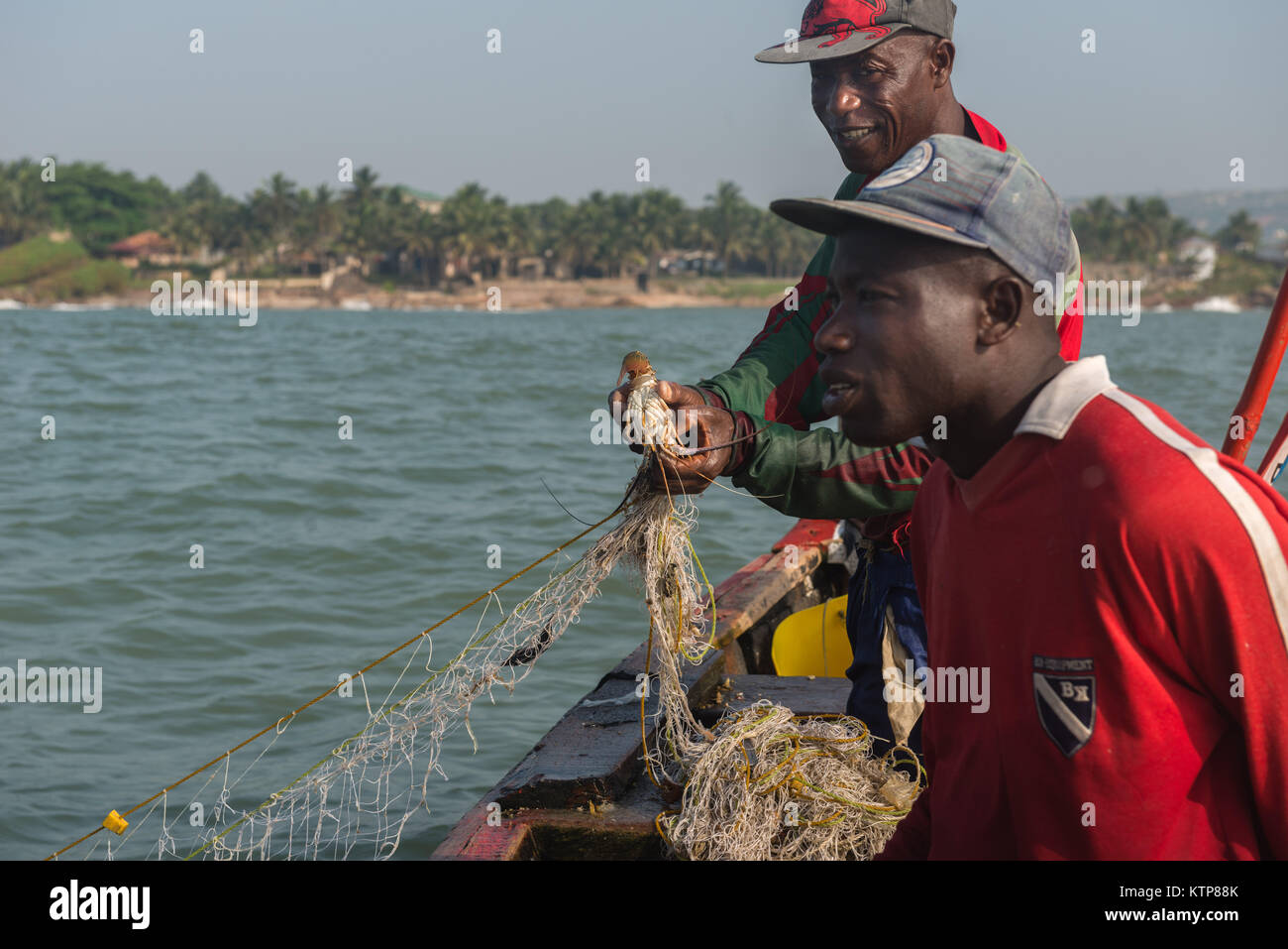 I pescatori nella loro barca open andare a pesca nelle prime ore del mattino. Essi racchetta da net a net per recuperare le loro catture, Kokrobite, maggiore Regione di Accra, Ghana Foto Stock