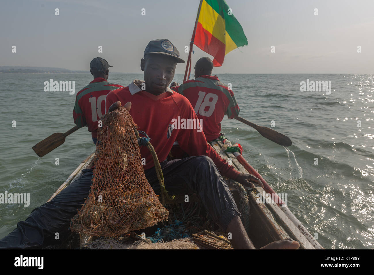 I pescatori nella loro barca open andare a pesca nelle prime ore del mattino. Essi racchetta da net a net per recuperare le loro catture, Kokrobite, maggiore Regione di Accra, Ghana Foto Stock