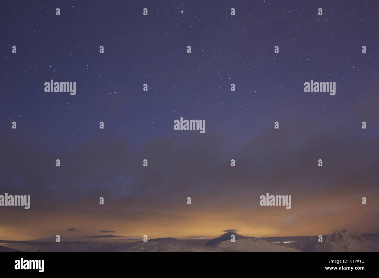Montagne retroilluminato parzialmente coperto di nuvole e il cielo stellato di notte Abow Foto Stock