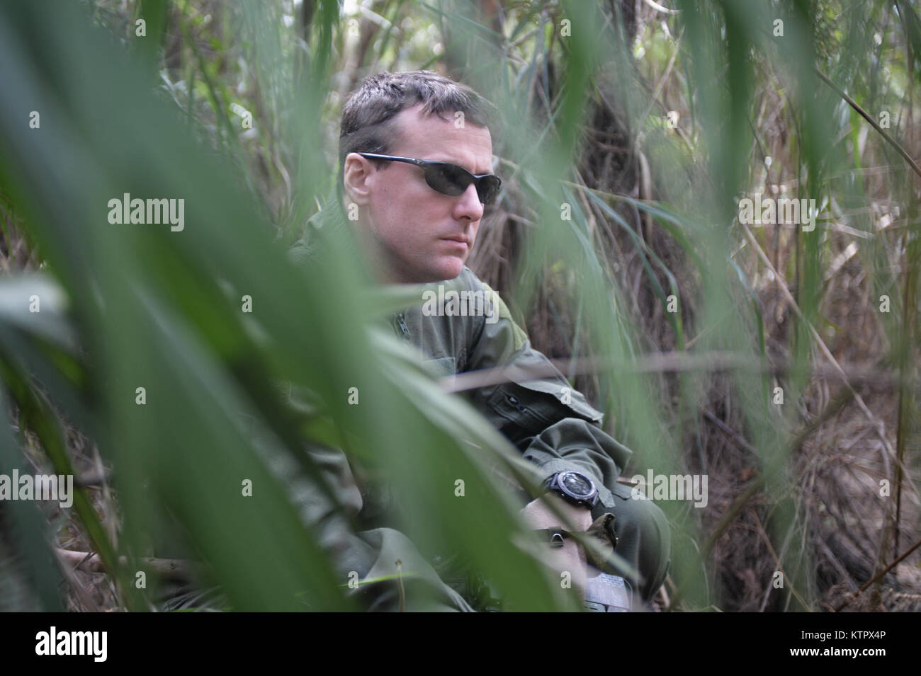 HOMESTEAD AIR BASE DI RISERVA, FLORIDA - Major Dave Sumwalt, un pilota con la 101st Rescue Squadron, tiene il coperchio durante un combattimento e acqua di sopravvivenza corso di formazione ad Homestead Air Base di riserva, Florida il 20 gennaio 2016. Durante questo corso di formazione, equipaggio membri guadagnato un training di aggiornamento utilizzando il proprio radio emergenza, movimenti tattici attraverso difficiult terreno, come costruzione di rifugi, modi di costruire gli incendi e i metodi per eludere il nemico. (US Air National Guard / Staff Sergente Christopher S. Muncy / rilasciato) Foto Stock