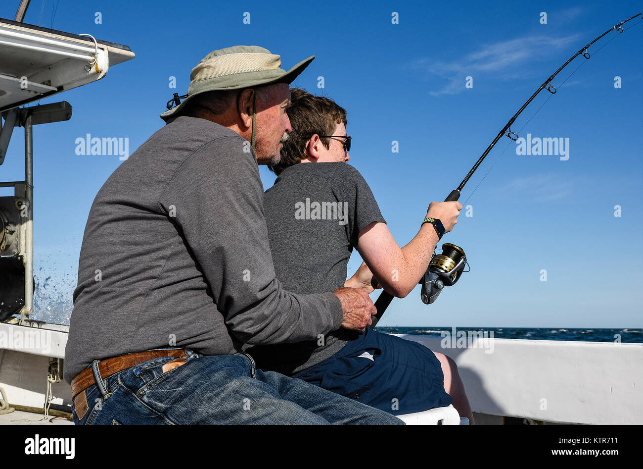 Nonno nipote incoraggia a portare un grande pesce, Chatham, Cape Cod, Massachusetts, STATI UNITI D'AMERICA. Foto Stock