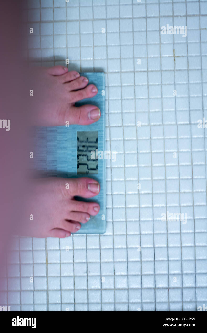 Uomo obesi sulla bilancia da bagno sulla pianificazione delle diete per la risoluzione di nuovi anni. Foto Stock
