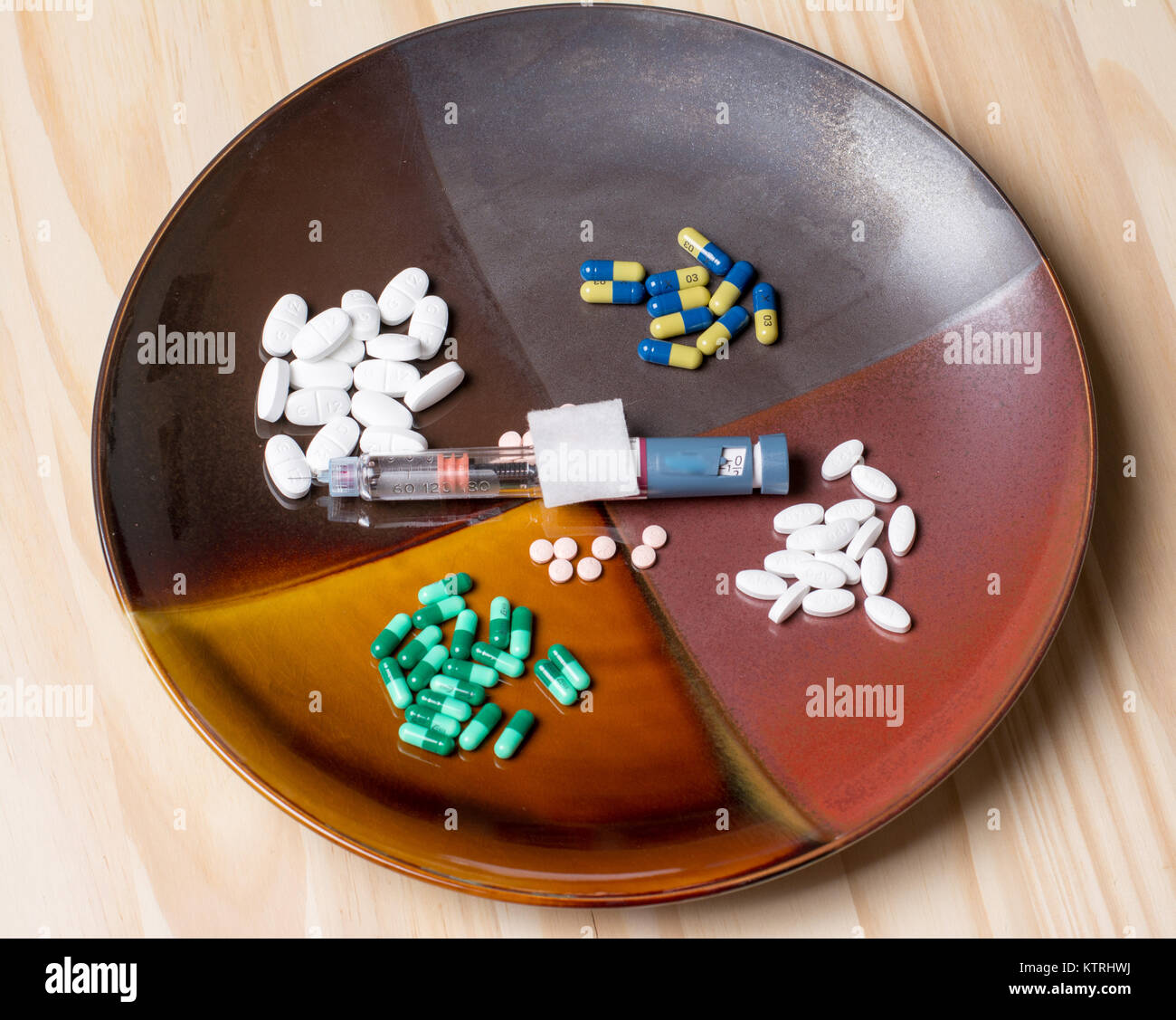 Assortimento di pillole su una piastra per cena che rappresenta il nostro giorno moderno hanno bisogno di per sé médicale. Foto Stock