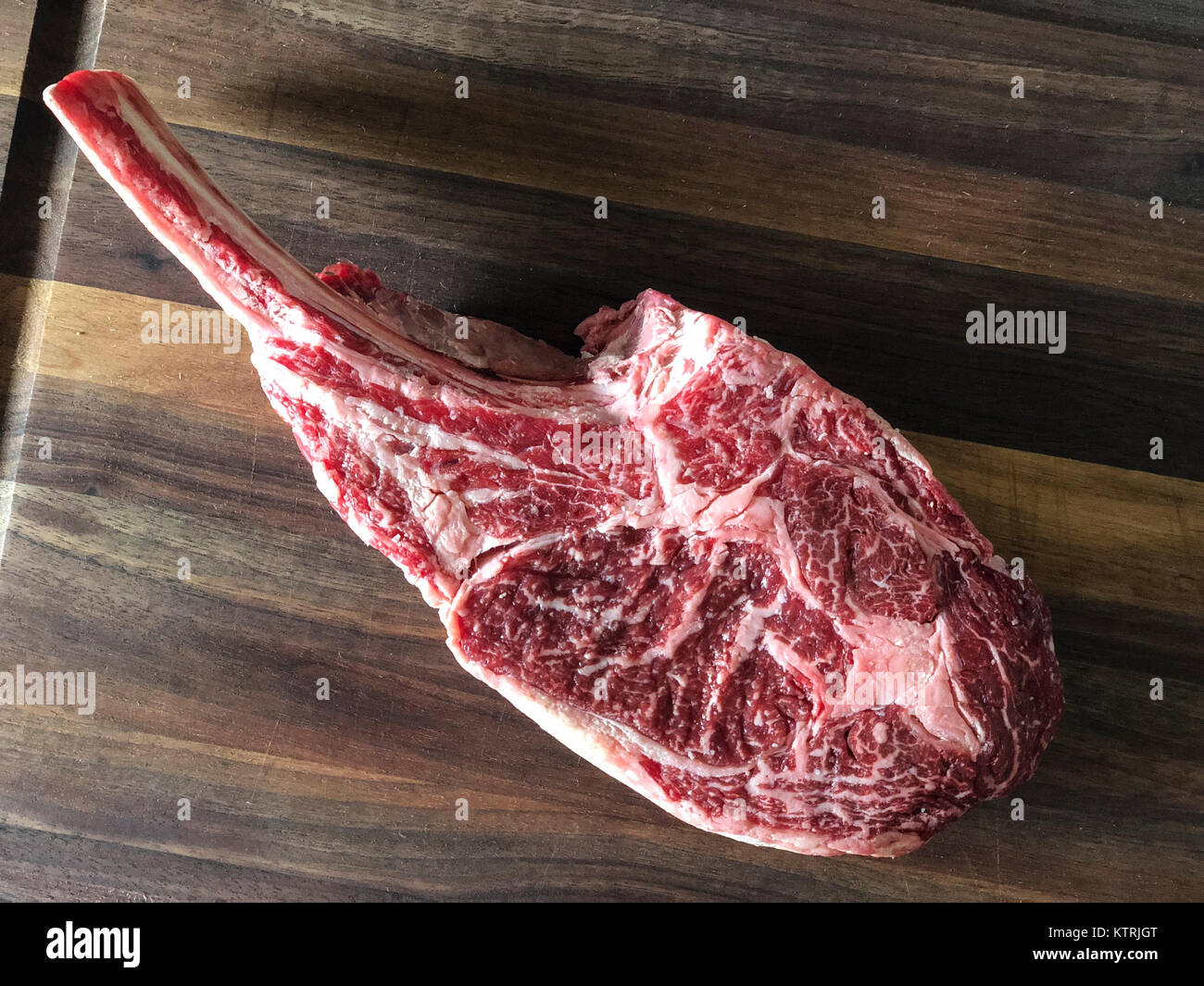 In prossimità delle materie di carni bovine. Tomahawk ribeye, osso, sul tagliere di legno. Foto Stock